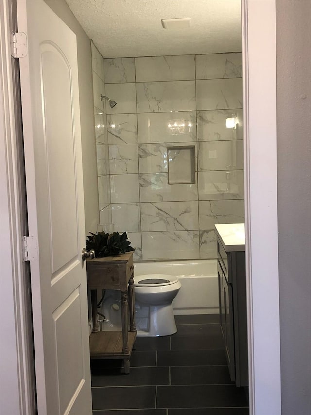 full bathroom featuring toilet, bathtub / shower combination, vanity, and a textured ceiling