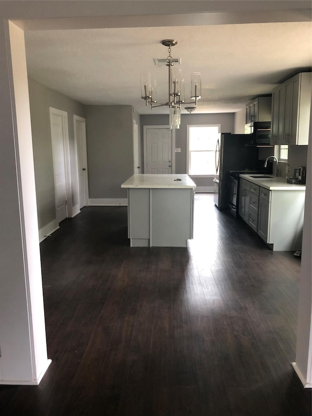 kitchen featuring dark wood finished floors, a kitchen island, visible vents, and a chandelier