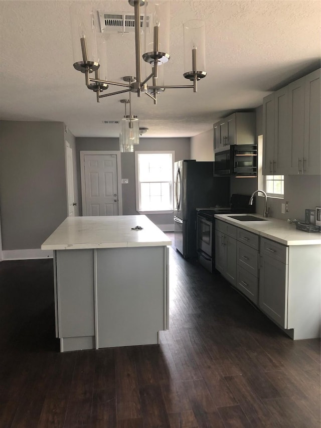 kitchen featuring a sink, a kitchen island, gray cabinets, and electric range oven