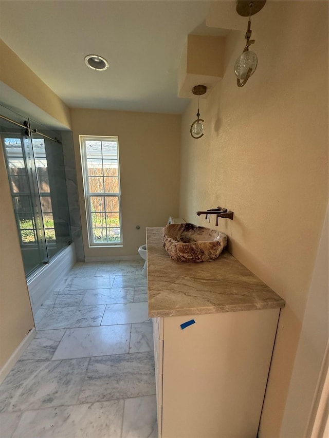 interior space featuring light countertops, baseboards, marble finish floor, and a sink