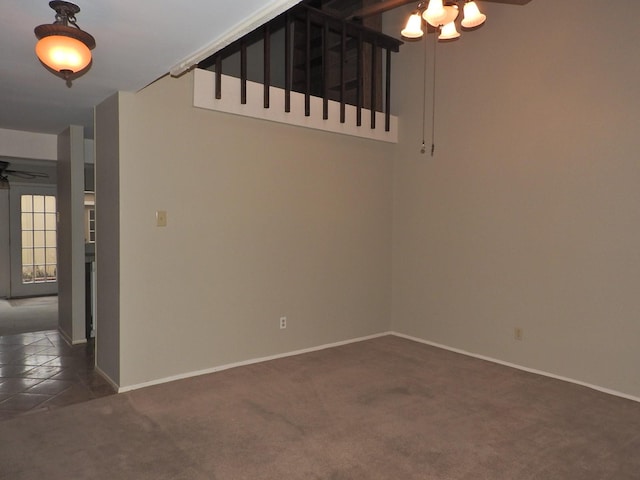 carpeted empty room featuring baseboards and ceiling fan