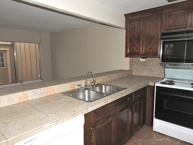 kitchen featuring electric stove, a sink, dark brown cabinetry, black microwave, and dishwasher