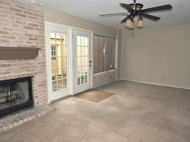 unfurnished living room with baseboards, a ceiling fan, a fireplace, and carpet flooring