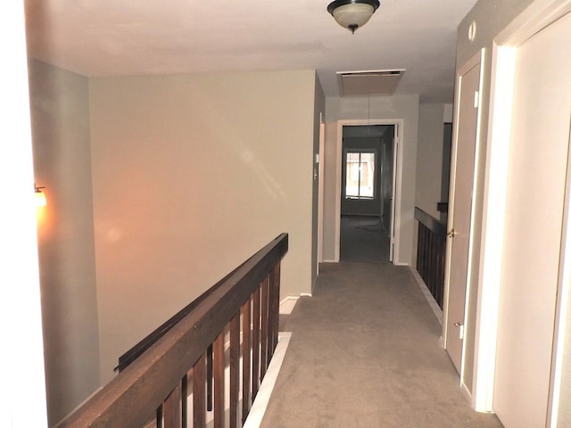 hallway featuring an upstairs landing, carpet, and attic access