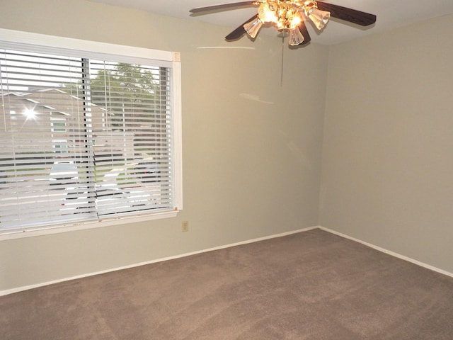 carpeted empty room featuring baseboards and ceiling fan