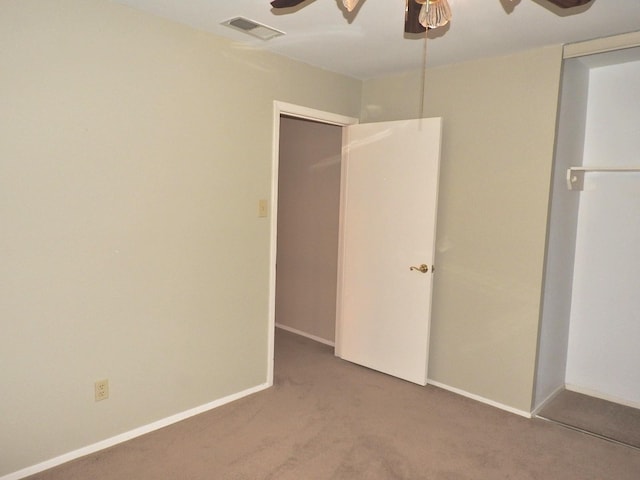 unfurnished bedroom with visible vents, carpet floors, baseboards, and a ceiling fan