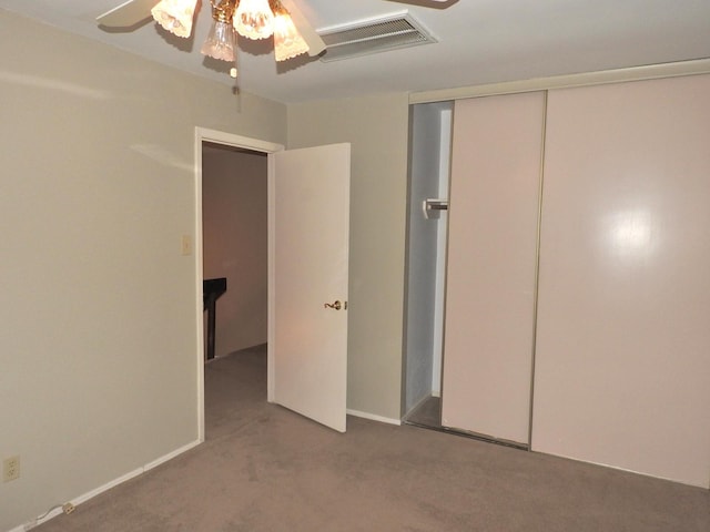 unfurnished bedroom with a closet, visible vents, carpet, and ceiling fan