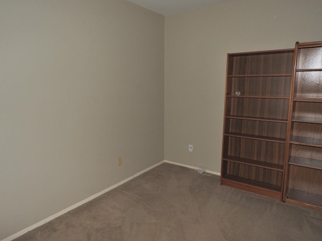 spare room featuring baseboards and carpet floors