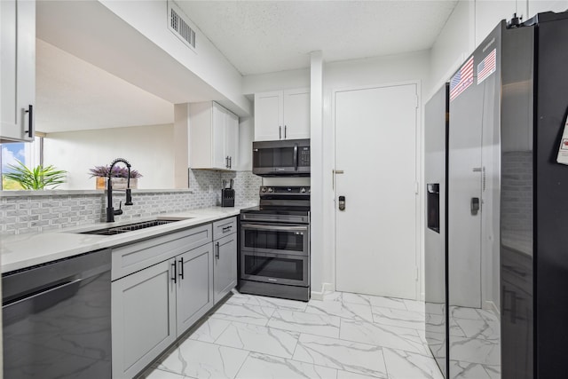 kitchen featuring visible vents, light countertops, marble finish floor, stainless steel appliances, and a sink