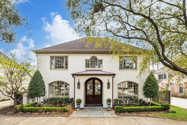 colonial home featuring french doors and brick siding