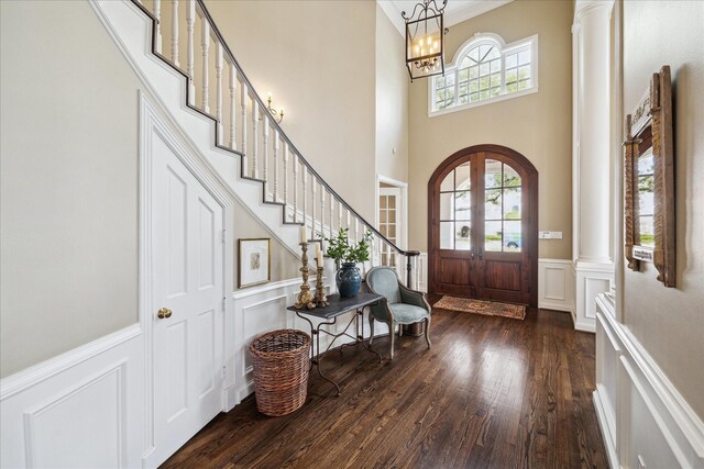 8521 Burkhart Rd, Spring Valley Village, TX 77055 - foyer with a wainscoted wall, arched walkways, dark wood finished floors, and ornate columns
