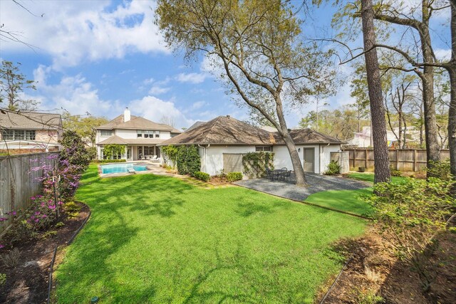 8521 Burkhart Rd, Spring Valley Village, TX 77055 - back of house featuring stucco siding, a lawn, a fenced backyard, a fenced in pool, and a patio area