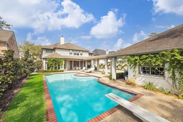 outdoor pool with a patio area and a diving board