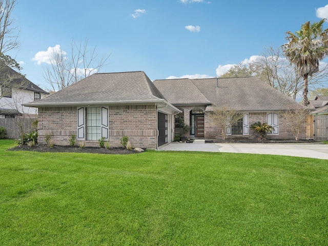 view of front of property featuring a front yard, a garage, brick siding, and driveway