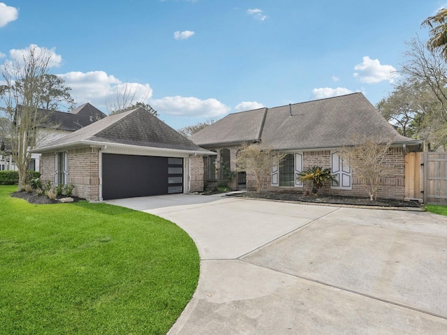 view of front of home featuring a front yard, driveway, roof with shingles, an attached garage, and brick siding