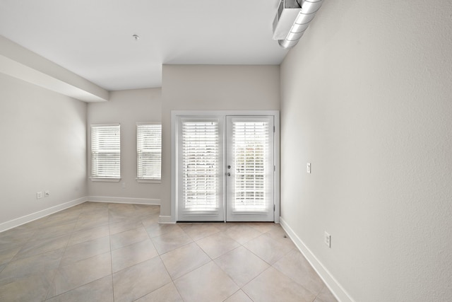 unfurnished room with light tile patterned floors, french doors, and baseboards