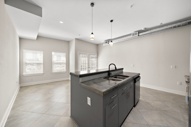 kitchen with dishwasher, dark countertops, light tile patterned floors, and a sink