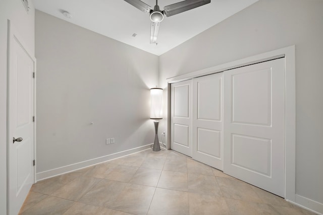 unfurnished bedroom with light tile patterned floors, a closet, baseboards, and ceiling fan