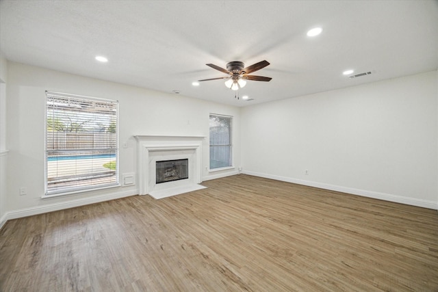 unfurnished living room with visible vents, a fireplace with flush hearth, a ceiling fan, recessed lighting, and light wood finished floors