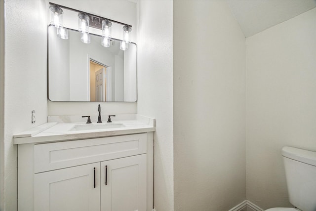 half bathroom with toilet and vanity