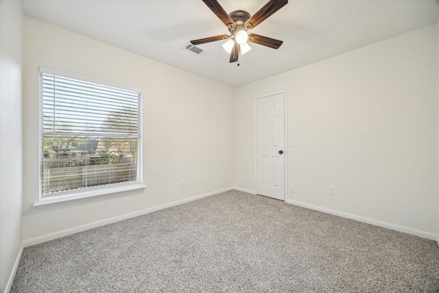 empty room featuring visible vents, baseboards, light colored carpet, and a ceiling fan