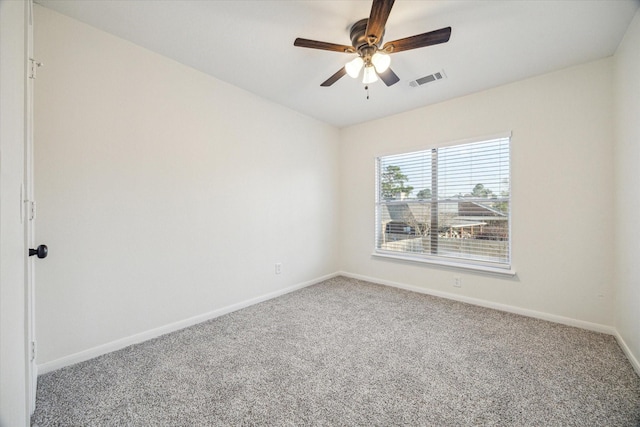 carpeted spare room with baseboards, visible vents, and ceiling fan