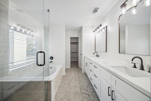 bathroom featuring a shower stall, a bath, double vanity, and a sink