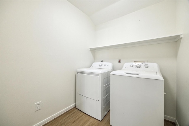 laundry area with washing machine and clothes dryer, laundry area, baseboards, and light wood-style floors