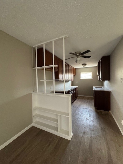 4706 Yellowstone Blvd, Houston, TX 77021 - kitchen with baseboards, ceiling fan, dark wood-type flooring, dark brown cabinetry, and a textured ceiling