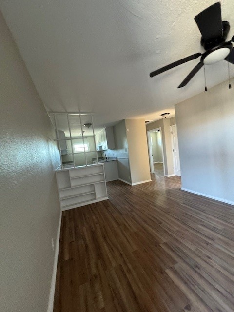 4706 Yellowstone Blvd, Houston, TX 77021 - spare room featuring a textured ceiling, a ceiling fan, dark wood-style flooring, and baseboards