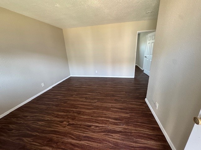4706 Yellowstone Blvd, Houston, TX 77021 - unfurnished room with baseboards, a textured ceiling, and dark wood-style flooring