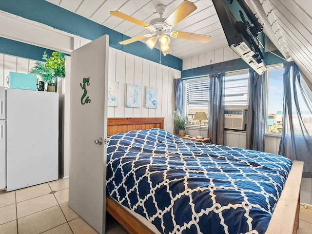 109 Beach Dr, Surfside Beach, TX 77541 - bedroom featuring tile patterned floors, cooling unit, freestanding refrigerator, a ceiling fan, and wood walls