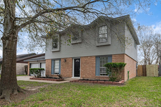 view of front of home with brick siding, a front yard, an attached garage, and fence