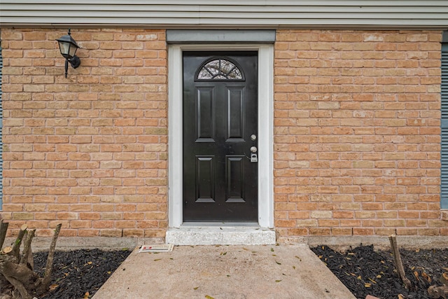 view of exterior entry with brick siding