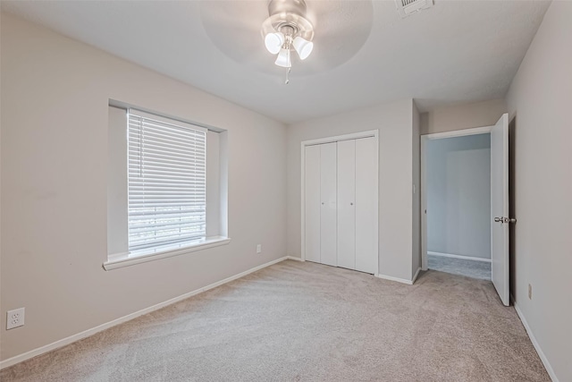 unfurnished bedroom featuring carpet, visible vents, a closet, and baseboards