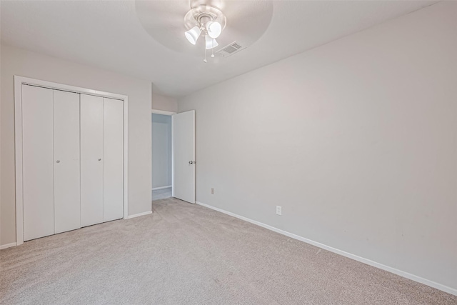 unfurnished bedroom featuring a closet, baseboards, visible vents, ceiling fan, and carpet