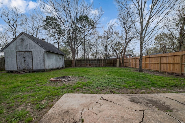 view of yard featuring an outdoor fire pit, an outbuilding, a fenced backyard, and a shed
