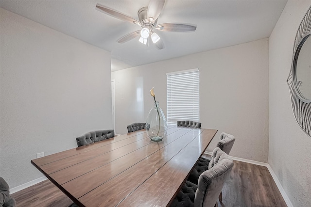 dining room with a textured wall, baseboards, a ceiling fan, and wood finished floors