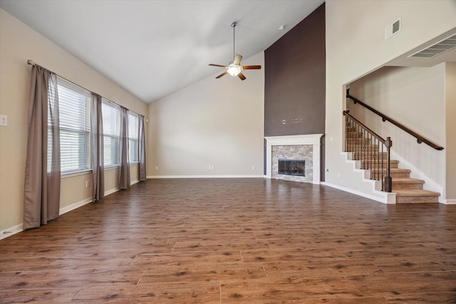 unfurnished living room featuring a ceiling fan, wood finished floors, a fireplace, and visible vents