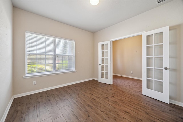 empty room featuring french doors, baseboards, and dark wood finished floors