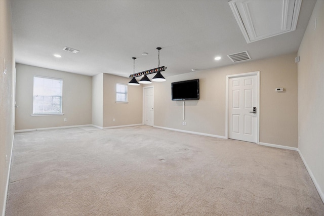 interior space featuring visible vents, light colored carpet, attic access, and baseboards