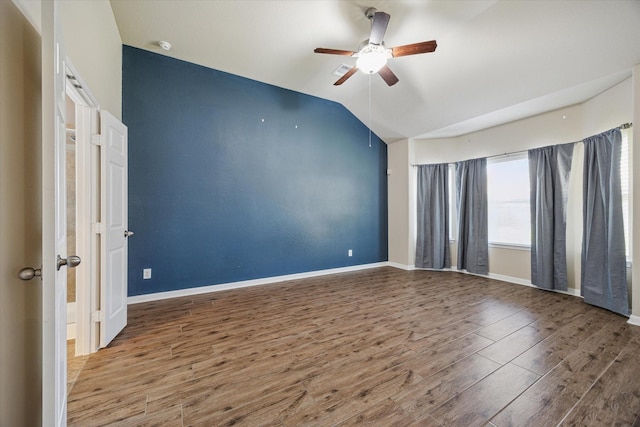 spare room featuring vaulted ceiling, baseboards, a ceiling fan, and wood finished floors