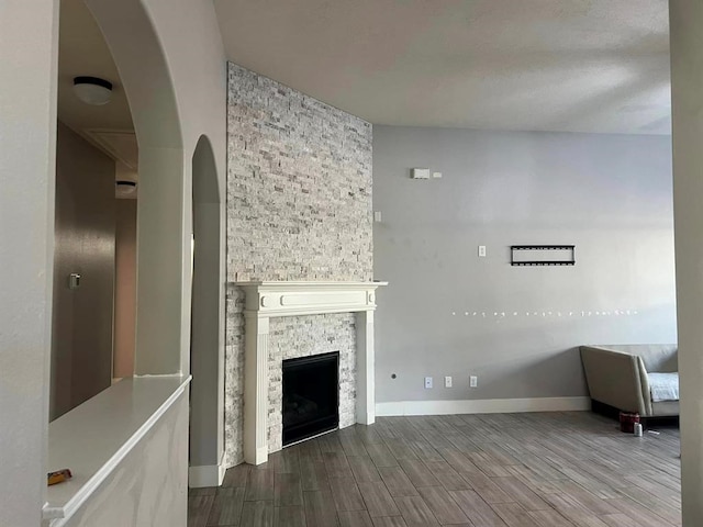 14538 Burleson Bend Dr, Houston, TX 77049 - unfurnished living room with baseboards, arched walkways, wood finished floors, and a fireplace