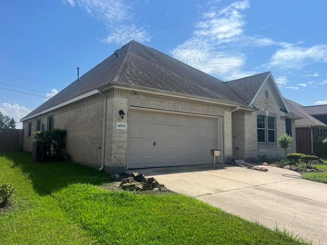 14538 Burleson Bend Dr, Houston, TX 77049 - view of property exterior featuring roof with shingles, a yard, concrete driveway, stone siding, and a garage