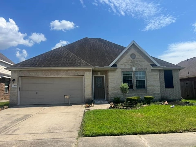 14538 Burleson Bend Dr, Houston, TX 77049 - single story home featuring concrete driveway, a front yard, roof with shingles, stone siding, and an attached garage