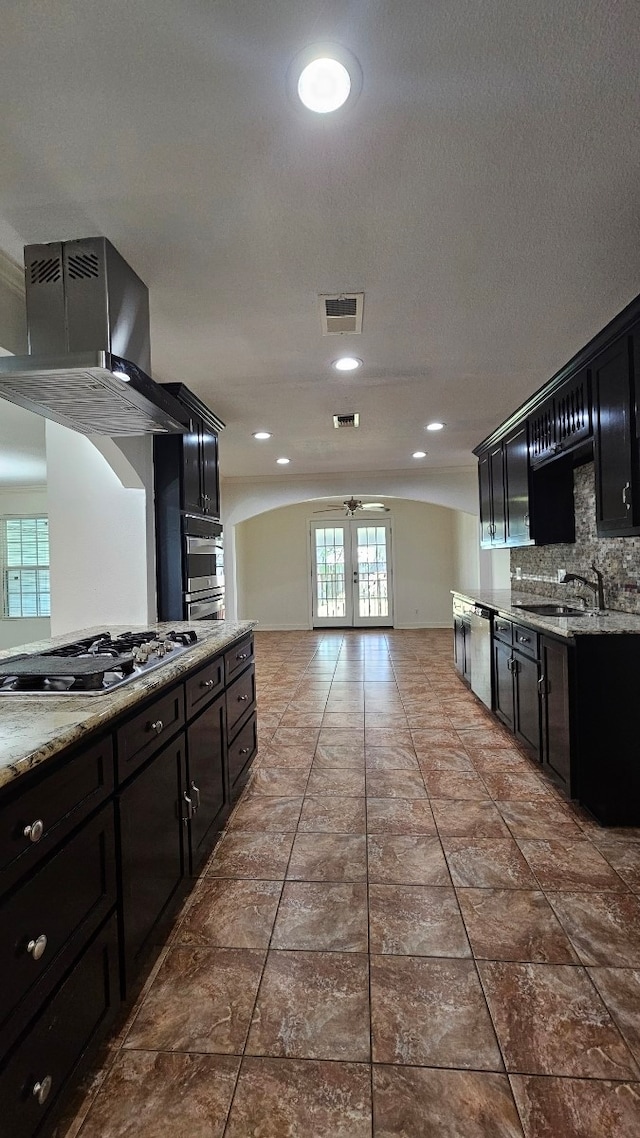 kitchen featuring french doors, stainless steel appliances, backsplash, a sink, and visible vents