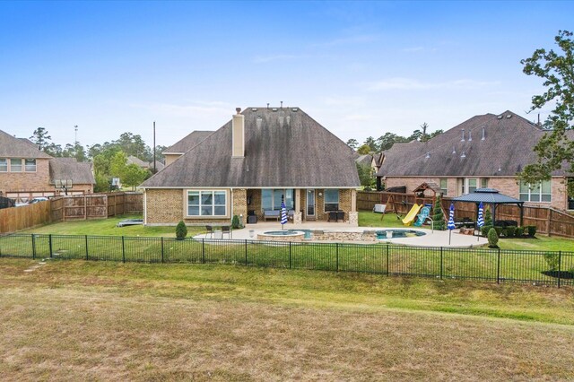 rear view of house featuring a playground, a patio area, a yard, and a chimney