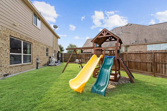 view of playground featuring a lawn and a fenced backyard