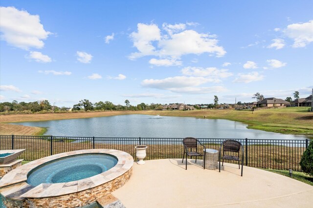 view of swimming pool featuring a water view, an in ground hot tub, fence, and a patio