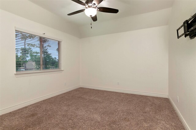 carpeted empty room featuring a ceiling fan and baseboards